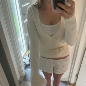 Vit omlottkofta från Mango - Säljer en superfin vit omlottkofta från Mango i mjukt material. Koftan har långa ärmar, knyt i midjan och en klassisk v-ringning. Perfekt att styla med linne under. Enkel och stilren design💕💕💕