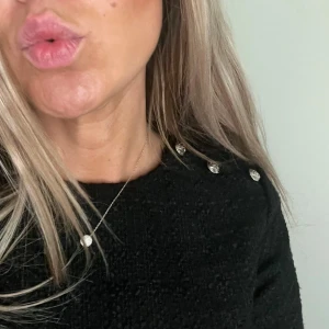 Nyskick! Bouclé topp med silvriga knappar - Svart kortärmad topp från H&M med dekorativa knappar på axeln. Köpt på H&M, i storlek S. Boxig passform.