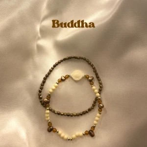 Buddha bracelet - 2 pack - Två stilrena elastiska armband, ett med små bruna pärlor och ett med vita och bruna pärlor samt en unik vit pärla i mitten. 
