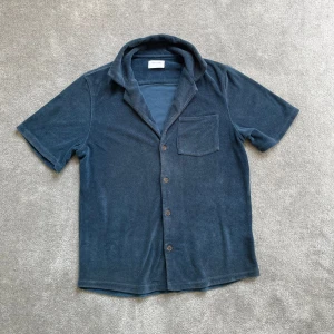 Mörkblå frottéskjorta - Säljer en mörkblå skjorta i frotté i XS/170! Skick 7/10. Hör gärna av er vid frågor!