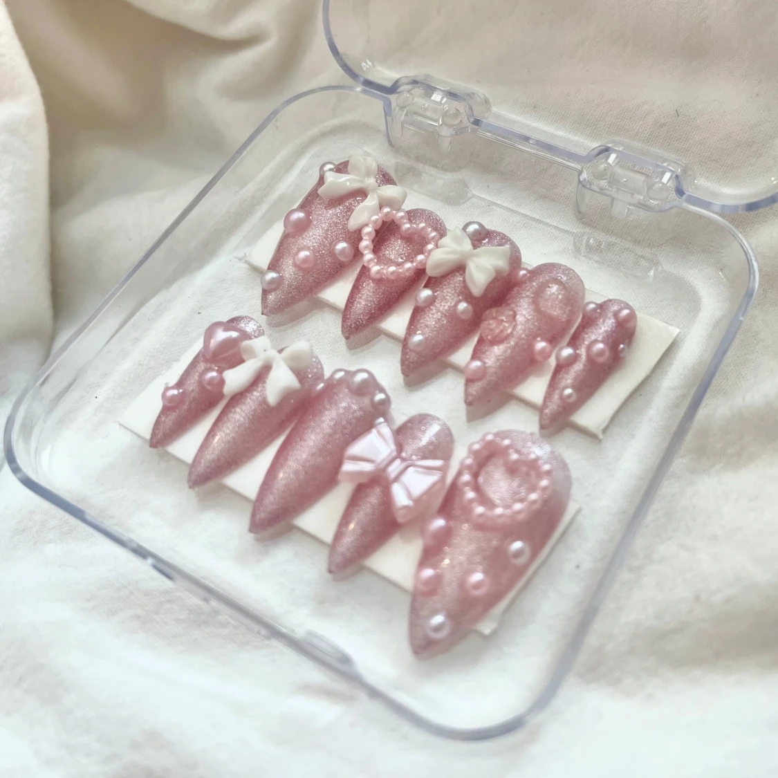 Rosa glittriga lösnaglar med pärlor och rosetter