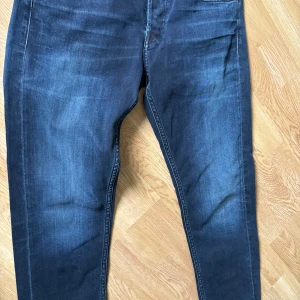Blå jeansbyxor Replay Grover Straight Fit - Säljer ett par klassiska blå jeansbyxor från Replay, modell Grover Straight Fit. Jeansen har normal passform, raka ben och fem fickor. Snygga slitningar framtill och bakficka med Replay-logga. Helt nya och helt oanvända.