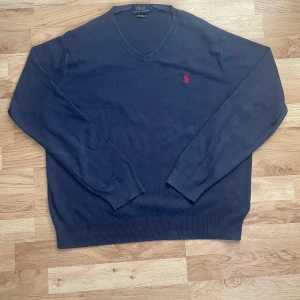 Ralph Lauren tröja blå - En riktigt snygg marinblå Ralph Lauren tröja med V-neck. Den är endast använd några gånger och i ett mycket bra skick. Storlek L. Hör av er vid frågor.😊