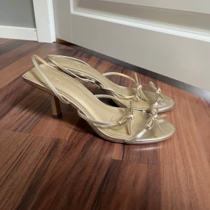 Guldiga klackar från nakd - Jättefina populära klackar från NA-KD Slutsålda på hemsidan Storlek 38 och knappt använda Klacken är 4 cm