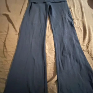 Mörkblå vida byxor från C - Mörkblå byxor med vida ben och stretchigt material från märket C. Byxorna har en hög midja och är perfekta för en avslappnad och trendig look. Passar dig som gillar bekväma och stilrena plagg.