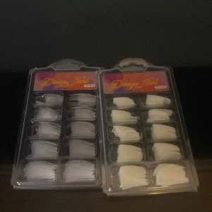 Design Nail tippar i plast - Två askar med vita och genomskinliga nageltippar i olika storlekar, perfekta för att bygga egna lösnaglar eller förlänga naglarna hemma. Kommer i praktiska plastaskar med fack för varje storlek.