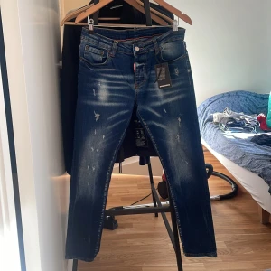 Blå jeans från Dsquared2 - Säljer ett par blå jeans från Dsquared2 med slitningar och snygg. Jeansen har normal passform och raka ben. Storlek M men passar även S. Pris kan diskuteras 