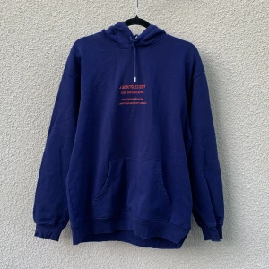 Mörkblå hoodie från Vailent med tryck - Säljer en mörkblå hoodie från Vailent i storlek M. Tröjan har magficka och tryck i orange både fram och bak. 50/50 bomull och polyester, och lätt oversized i passformen.