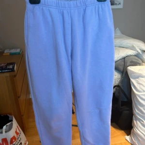 Ljuslila mjukisbyxor från Weekday - Säljer ett par ljuslila mjukisbyxor från Weekday med resår i midjan. Byxorna har en avslappnad passform och är perfekta för en chill stil. Tillverkade i mjuk bomull för extra komfort.