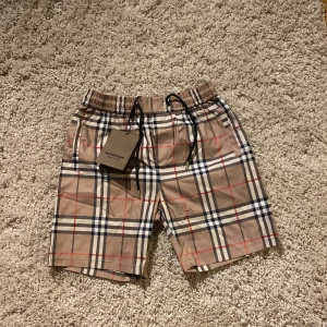 Burberry shorts - Snygga beige shorts från Burberry, shortsen är som badbyxmatrial och är helt nya! De är ganska små i storleken.