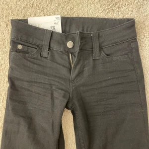 Svarta bootcut jeans från Cheap Monday - Säljer ett par svarta bootcut jeans från Cheap Monday med låg midja. Klassisk femficksmodell med dragkedja och knapp framtill. Jeansen har Cheap Monday-logga bak och är tillverkade i bomull med lite stretch för skön passform. Storlek w24 L30💕De är i nyskick och är aldrig använda då jag råkade köpa fel storlek.