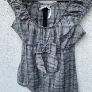 2000-tal inspirerad rutig blus med rosett 🎀 - TAR EMOT PRISFÖRSLAG ❤️❤️ Supersöt rutig blus från Antik Batik, perfekt för sommaren! ☀️ Köptes secondhand- men har inte använts och har inga defekter! Tunt och luftigt material, perfekt för vår och sommar.