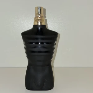 Jean Paul Gaultier Le Male Le Parfum - Säljer en elegant parfym från Jean Paul Gaultier, Le Male Le Parfum. Flaskan är formad som en svart torso med guldiga detaljer och kommer i en stilren svart förpackning med guldtext. Perfekt för den som vill ha en sofistikerad och maskulin doft. OBS PRIS EJ HUGGET I STEN