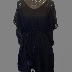 Svart kort strandklänning  - Strand klänning kör i bulgaren för cirka 300kr. Andvändes endast där. Nej det är inte en fläck min kamera ser spöken ibland. Den är rätt kort och går att dra åt i midjan. Perfekt till sommaren och stranden. 