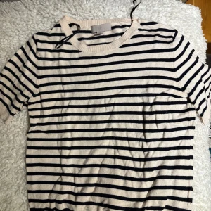 Randig kortärmad tröja i bomull - Säljer en vit och marinblå randig tröja med korta ärmar och rund halsringning. Säljer även den som enbart är vit också. Tröjan är i mjuk bomull och har en klassisk, avslappnad stil som passar perfekt till jeans eller kjol.  2 för 250kr annars  150kr/st