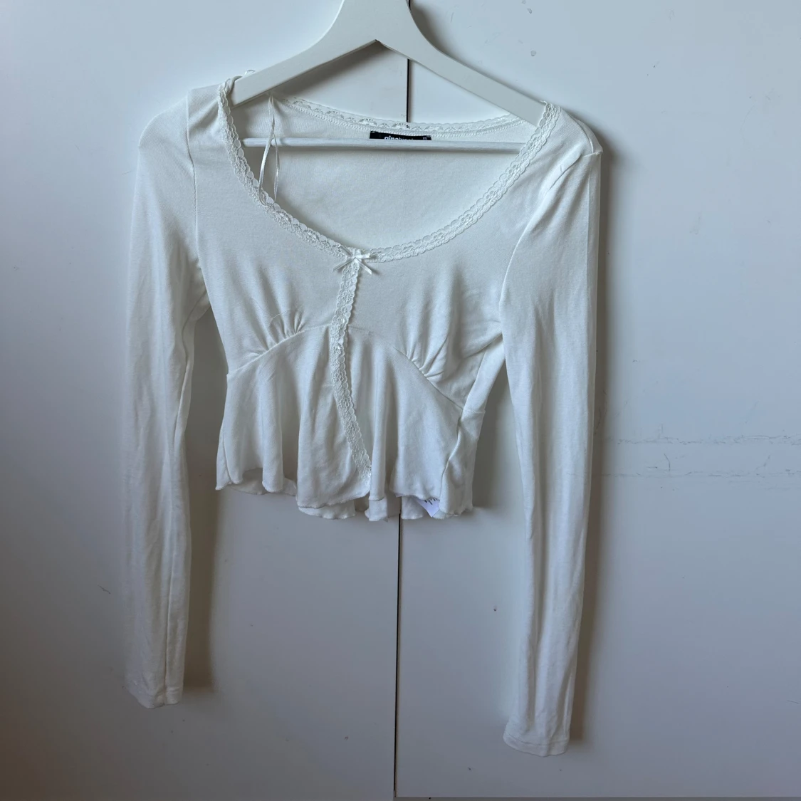 Vit långärmad topp med spets och rosett