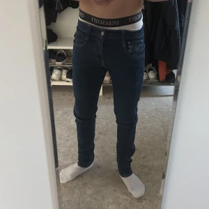 Mörkblå slim replay jeans hyperflex - Snygga mörkblå jeans med slim passform och klassisk femficksdesign. Jeansen har tydliga sömmar och är tillverkade i stretchigt denimtyg som sitter tajt men bekvämt längs benen. Perfekta för en stilren och modern look. Inga hål. Storlek 30