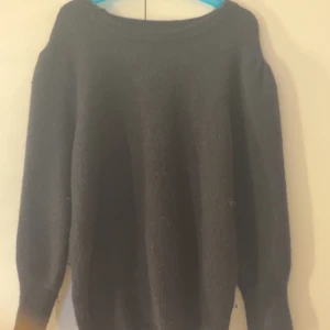 Svart stickad tröja med rund hals - En enkel svart stickad tröja med rund halsringning och långa ärmar. Perfekt för lager-på-lager och funkar till både jeans och kjol. Mjuk och skön känsla, passar dig som gillar en klassisk och clean stil.