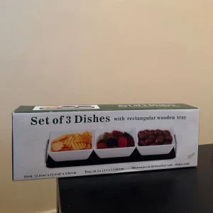 Set of 3 dishes - Ett set med tre vita skålar på en rektangulär svart träbricka. Perfekt för snacks, godis eller dip till filmkvällen. Skålarna är mikrovågs- och diskmaskinssäkra. Snygg och praktisk design som passar i alla hem. Finns tre stycken helt oanvända