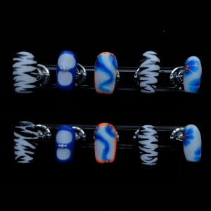 Handgjorda lösnaglar med mönster - Säljer ett set handgjorda lösnaglar med olika mönster: blå och vita naglar med pärldekor, naglar med blå, vit och orange, svartvita zebramönstrade naglar samt naglar med blommor. Perfekt för dig som vill ha unika och kreativa naglar.