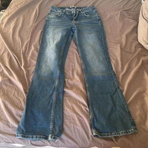 Blå bootcut jeans  - Stilrena blå jeans i bootcut/straight modell – sitter snyggt och ger en smickrande siluett! Jeansen har klassisk passform och är perfekta för både vardag och kväll. De är använda ett fåtal gånger och har små tecken på användning nedtill vid bensluten, inget som påverkar helhetsintrycket. 💌 Köparen står för frakten. 