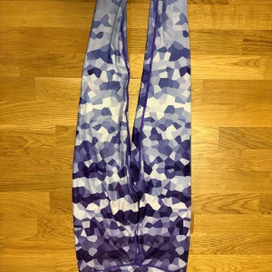 Lila mönstrade träningstights från Icanwill - Säljer ett par lila och vita träningstights från Icanwill med ett unikt geometriskt mönster. Tightsen har en tight passform och är tillverkade i ett stretchigt syntetmaterial som passar perfekt för träning.