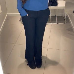 Svarta kostymbyxor med bootcut - Snygga svarta kostymbyxor med bootcut passform. Byxorna har en klassisk look med normal passning och raka ben som blir lite utsvängda nertill. Perfekta att styla med en stickad tröja eller skjorta. 💌Köparen står för frakten!