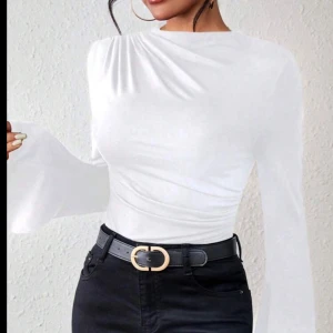 Vit långärmad topp från SHEIN - Säljer en vit långärmad topp från SHEIN med draperad detalj på sidan. Toppen har en figurnära passform och är tillverkad i ett stretchigt polyestermaterial. Perfekt till att styla med jeans eller kjol. Storlek L helt oanvänd