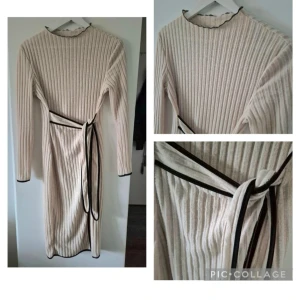 Beige ribbad klänning med knytband - Snygg beige ribbad klänning med långa ärmar och ett svart knytband i midjan. Klänningen har en stilren design med svarta detaljer vid hals och ärmslut. Perfekt för en chic och avslappnad look.
