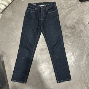 Mörkblå jeansbyxor - Snygga mörkblå jeansbyxor med klassisk femficksdesign och kontrastsömmar. Perfekta för en avslappnad stil. De har en rak passform och är tillverkade i slitstarkt denim.