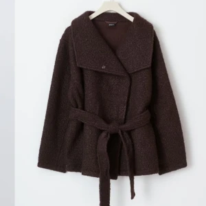 Brun kappa med bälte - Snygg brun kappa med bälte och bred krage. Perfekt för kyligare dagar med sin långa ärm och stilrena design. Inköpt för ungefär en månad sen och har används ungefär 2-3 gånger!