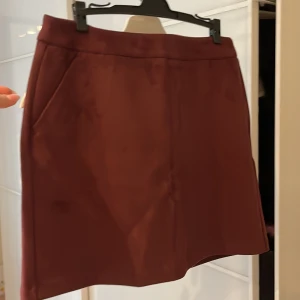 Linne - Vinröd kjol med dragkedja på baksidan. Aldrig använd med lapp kvar. 