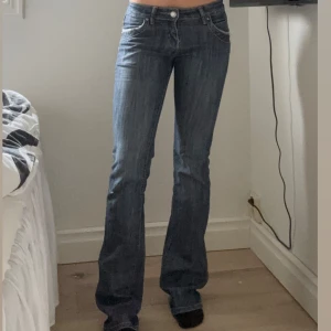 Blå bootcut jeans - Snygga blå bootcut jeans. Med låg midja! Dessa jeans har varit lite för långa för mig,  vilket har blivit lite slitage längst ner. Det står ingen storlek, men jag har 36 och dom passar super! Hör av er för fler bilder och mått privat🥰