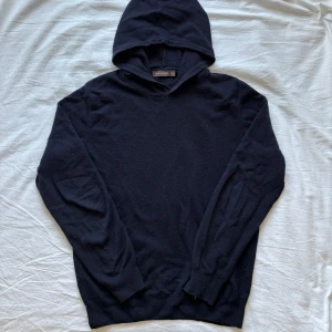 Navy hoodie från Oscar Jacobson - Säljer en stilren svart hoodie från Oscar Jacobson i storlek S. Tröjan är tillverkad i en mjuk blandning av ull, viskos och kashmir. Inga hål eller skador. 