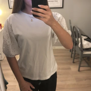 Vit topp från Kappahl - Säljer en söt vit topp från Kappahl i storlek XS passar även bra i S. Toppen har korta puffärmar med broderade detaljer
