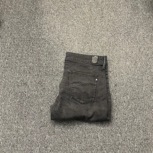 Replay jeans - Snygga svarta jeansbyxor med klassisk femficksdesign. De har en diskret logga på bakfickan och en knappstängning i midjan. Perfekta för en stilren look.