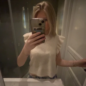 Vit volang topp - Säljer en fin vit/beige tröja från Vero Moda med volangdetaljer längs ärmarna. Tröjan är i en mjuk och bekväm kvalite. Det står på tröjan att den är i storlek xl men sitter som en xs/s. När jag köpte tröjan så sa hon i kassan att det säkert hade blivit nått fel!!