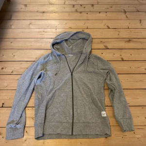 Zip hoodie - SUPERKAP! - Säljer en stilren grå hoodie från Jack & Jones Essentials. Den har inte kommit till användning hos mig så den är i princip i NYSKICK! Den har en dragkedja framtill och en praktisk huva med snörning. Vid funderingar kring pris eller fler bilder så är det bara att kontakta mig! Kolla även in min sida. Säljer kläder sjukt billigt och då har du chansen att köpa bundles…Med vänlig hälsning, 👋  