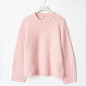 Rosa stickad tröja - Mysig rosa stickad tröja med rund hals och långa ärmar. Perfekt för kyligare dagar och ger en mjuk och bekväm känsla. Passar bra till både jeans och kjol för en avslappnad look.