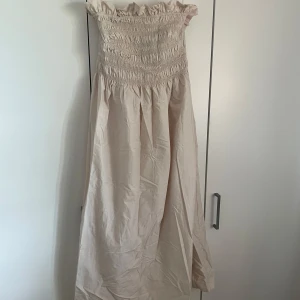 Ljus offshoulder långklänning från H&M - Säljer en ljus långklänning från H&M med smock upptill och offshoulder-modell. Perfekt för varma dagar🤍