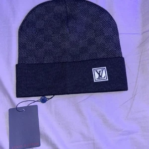Mörkgrå mössa! - Snygg mörkgrå mössa  med diskret rutig design och vikt kant. L V logga framtill på kanten. Perfekt accessoar en snygg outfit. Pris kan diskuteras!