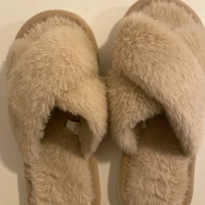Tofflor beige  - Supermjuka och fluffiga sandaler i beige färg med korsad design upptill. Köpt från temu