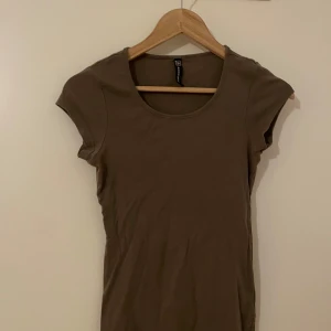 grön kortärmad topp  - Säljer en enkel olivgrön topp med rund halsringning och korta ärmar. Perfekt att matcha med jeans eller kjol för en avslappnad stil. 