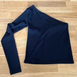 Svart festtopp med en ärm - Säljer en oanvänd svart festtopp med en ärm. Den är från Lindex i storlek S, men passar även mindre då den är ganska tight. 40kr plus frakt, välj gärna instabox om möjligt