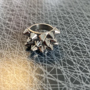 Silvrig ring med nitar - Edblandring silver, vet inte riktigt storlek med den är ganska lite helt nyss skick. Äkta finns märke på insidan.