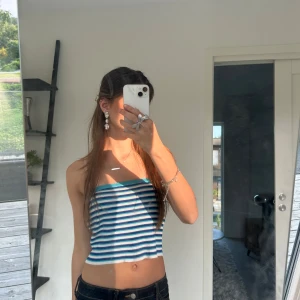 Randig tubtopp i blått och vitt - Säljer en snygg randig tubtopp i blått och vitt från Åhléns i märket Carin Wester. Toppen är croppad och passar perfekt sommaren. Enkel och stilren design som passar till mycket. 