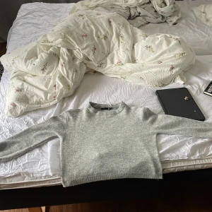 Ljusgrå stickad croppad tröja från lager 157 - Säljer en ljusgrå stickad Tröjan från lager har rund halsringning och långa ärmar. Perfekt att styla med höga jeans eller kjol.