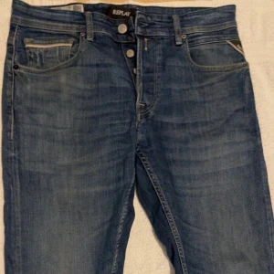 Blå Replay Grover jeans straight fit - Säljer ett par klassiska blå jeans från Replay, modell Grover. Byxorna har raka ben, fem fickor och snygga detaljer på bakfickorna. Perfekta för dig som gillar en tidlös jeansstil med bekväm passform. Knappt använda och i bra skick. Storlek waist 31 och längd 34
