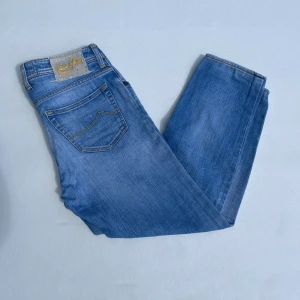 Jacob Cohen Jeans - Säljer nu dessa Jacob Cohen jeans i en fin blå sommar färg. Storleken på dessa är 32 och modellen är 622 Comfort. Det är en lite defekt vid skrevet som är lagat därav priset. 7/10. Midja mått 40cm lår mått 24cm ytterlängd mått 90cm innerlängd mått 68cm. För fler frågor eller funderingar är det bara att höra av sig!