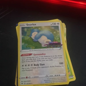 Snorlax - Detta är ett samlarkort med Snorlax från Pokémon-serien. Perfekt för dig som gillar att samla på Pokémonkort eller vill ha en cool detalj till din samling. Kortet har 130 HP och två attacker: Gormandise och Body Slam.